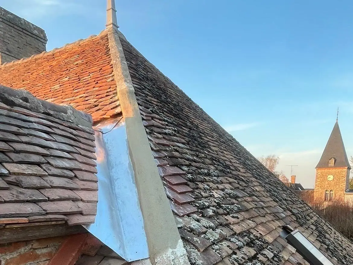 Noue neuve au pied d'une lucarne, arêtier au mortier et épi de faîtage sur une toiture en tuiles plates anciennes